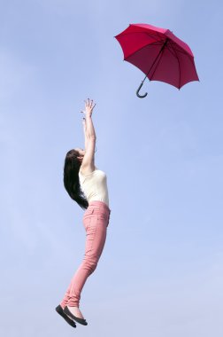 kadın şemsiye ile mavi gökyüzüne jumping