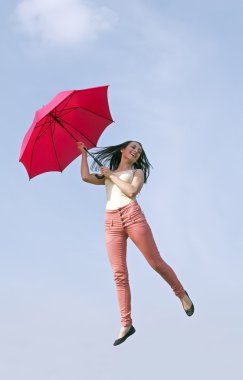 kadın şemsiye ile mavi gökyüzüne jumping