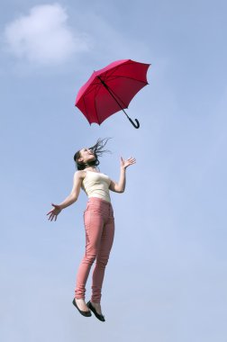 kadın şemsiye ile mavi gökyüzüne jumping