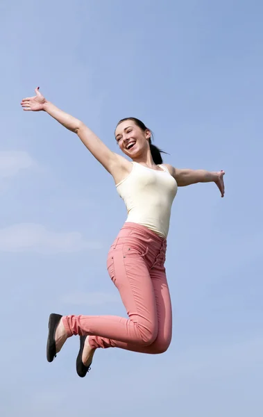 Frau springt in den blauen Himmel — Stockfoto