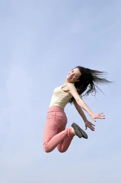 Frau springt in den blauen Himmel — Stockfoto