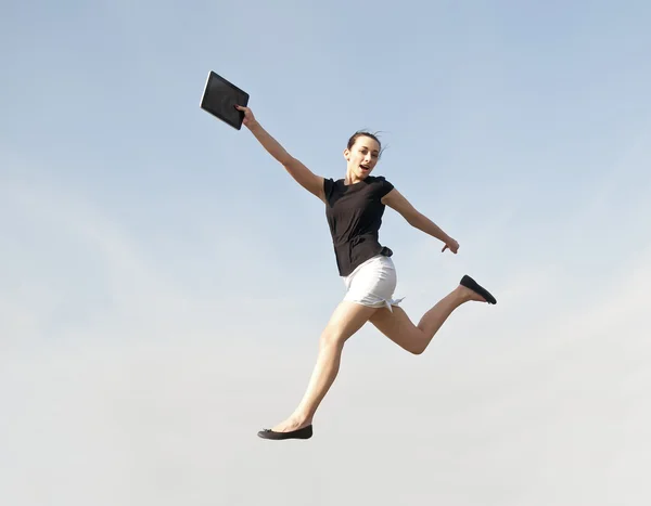 Vrouw springen met tablet pc — Stockfoto