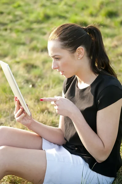 Femme avec tablette pc sur une prairie — Photo