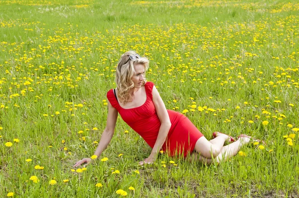 Woman relaxing in dandelion meadow — Stock Photo, Image