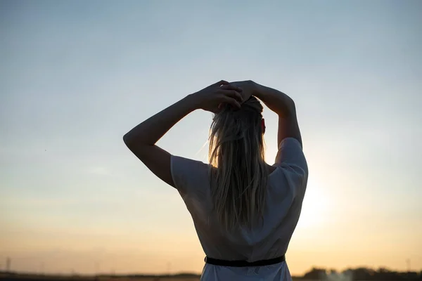 幸せな若い金髪の女性が夕日を楽しんでリアビュー — ストック写真