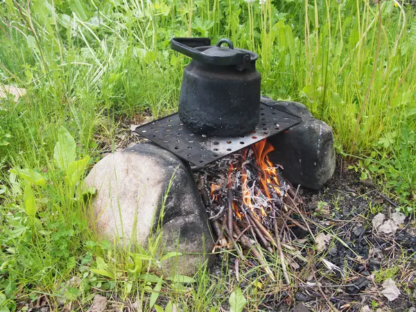 Theepot en waterkoker op een brand in de zomer — Stockfoto