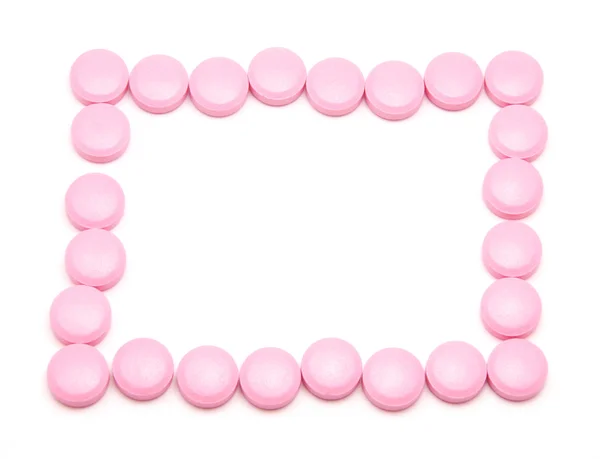Розовые таблетки на белом фоне — стоковое фото