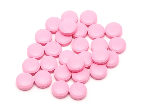 Růžové tablety na bílém pozadí — Stock fotografie