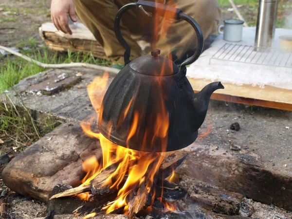 Theepot en waterkoker op een brand in de zomer — Stockfoto