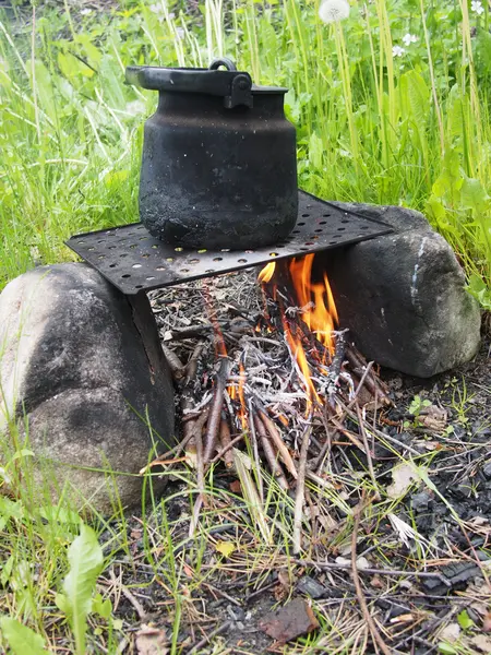 Teekanne und Wasserkocher auf dem Feuer im Sommer — Stockfoto