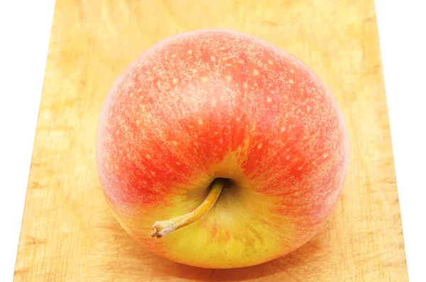 Яблуко на обробній дошці — стокове фото