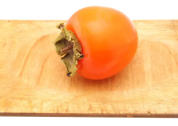 Persimmon on a cutting board on white — Stock Photo, Image