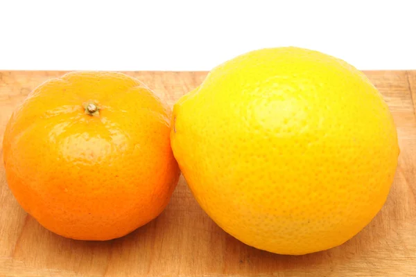 Lemon and mandarin orange on a cutting board — Stock Photo, Image