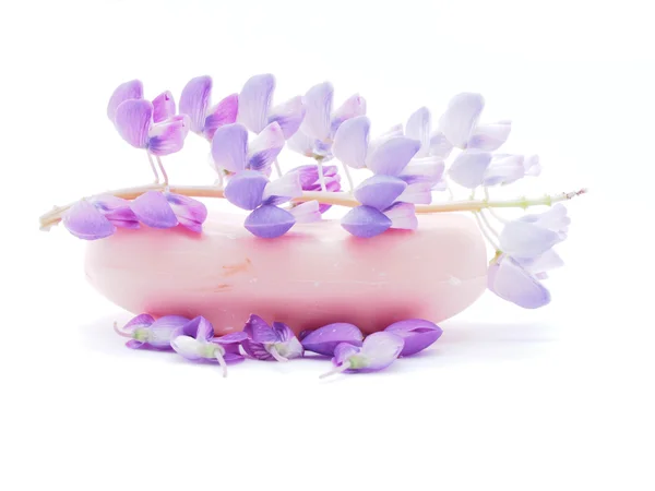 Seife und Blumen auf weißem Hintergrund — Stockfoto