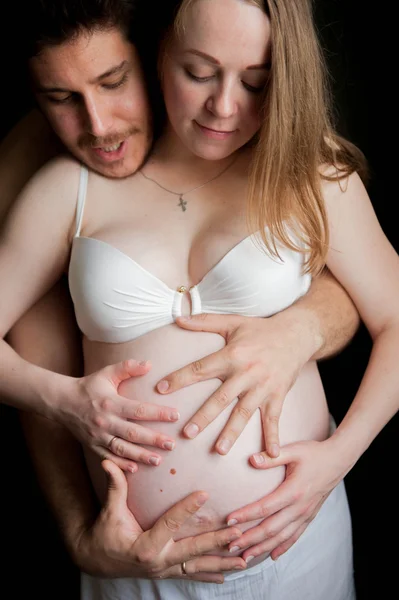 Чоловік обіймає свою вагітну дружину. — стокове фото