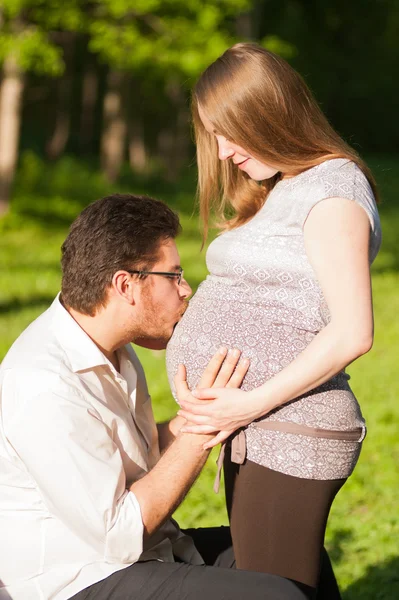 mide hamile bir kadının bir adamı öpüyor