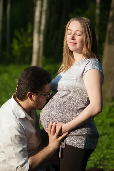 En man omfamnar en gravid kvinna — Stockfoto