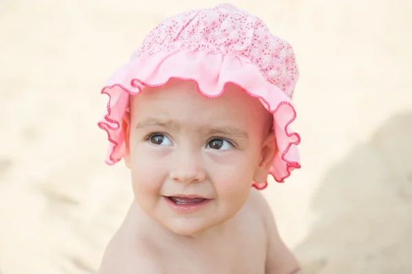 Ritratto di una bambina sorridente con un cofano rosa primo piano — Foto Stock