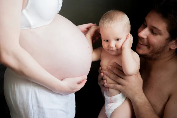 Uma criança toca a barriga de uma mulher grávida — Fotografia de Stock