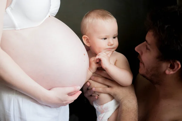Un niño toca el vientre de una mujer embarazada —  Fotos de Stock