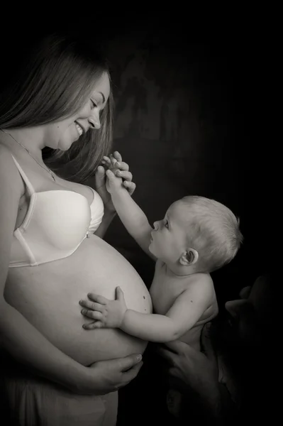 Ein Kind berührt den Bauch einer schwangeren Frau — Stockfoto