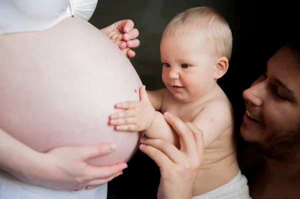 Un enfant touche le ventre d'une femme enceinte — Photo