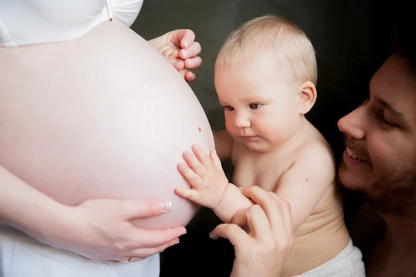 Een kind raakt de buik van een zwangere vrouw — Stockfoto