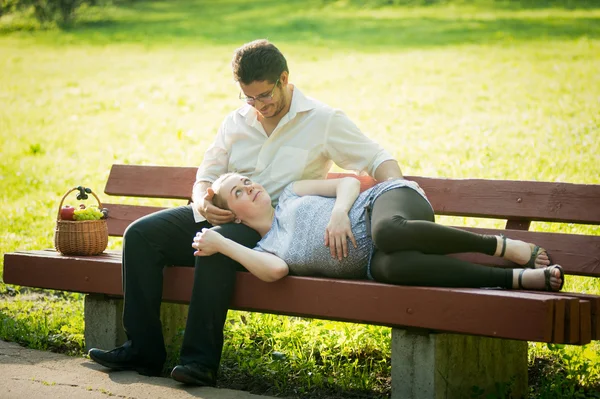 Pregnant woman with her husband in the park — Stock Photo, Image