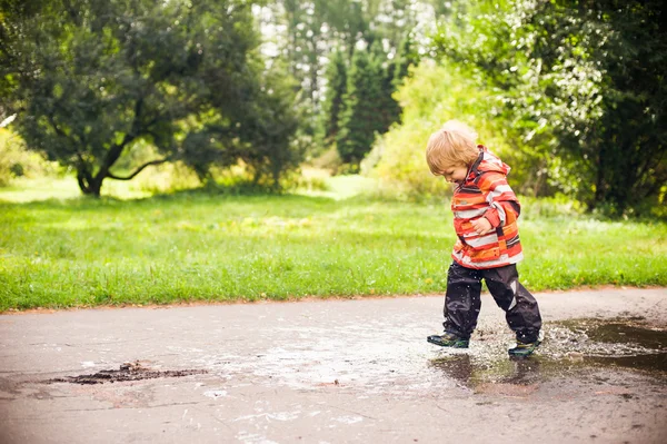 Niño corriendo y saltando en charcos —  Fotos de Stock