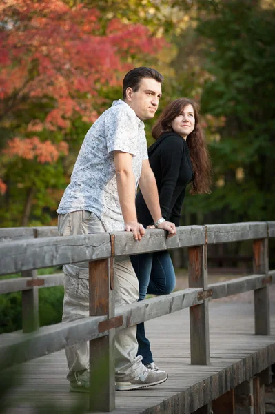 Couple amoureux sur le pont dans le parc — Photo