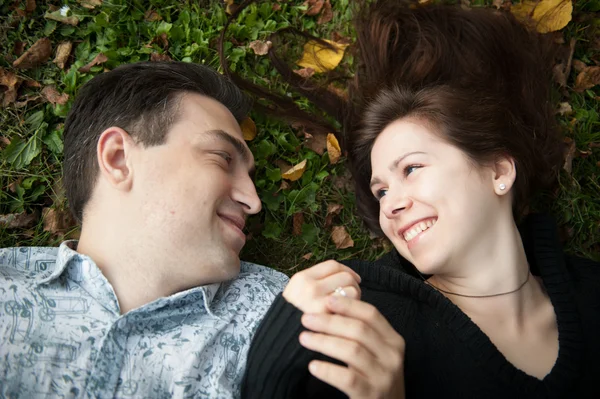 Pareja cariñosa acostada en la hierba — Foto de Stock