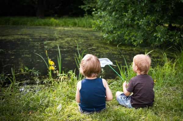 Two boys on a pond Royalty Free Stock Photos