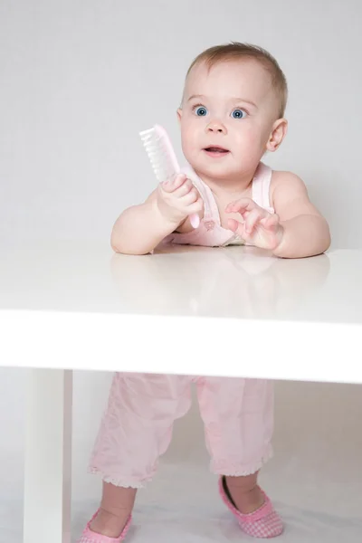 Menina bonito com uma escova de cabelo — Fotografia de Stock