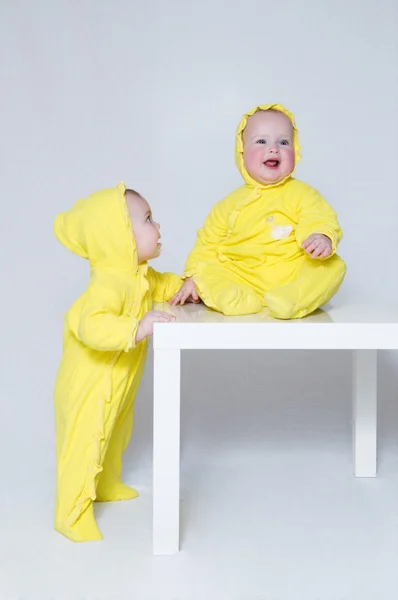 Duas meninas bonitos nos mesmos ternos amarelos — Fotografia de Stock