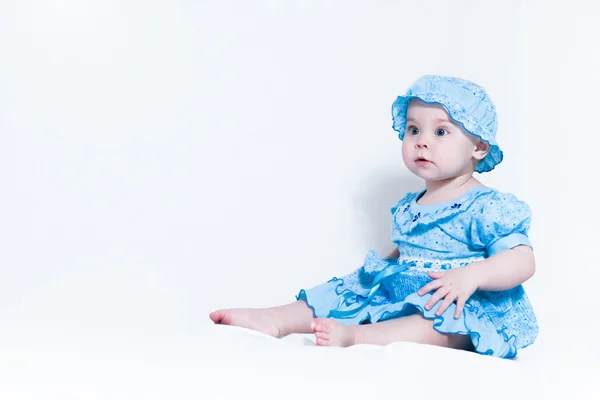 Χαριτωμένο μικρό κορίτσι σε ένα μπλε φόρεμα και ένα καπέλο — Φωτογραφία Αρχείου