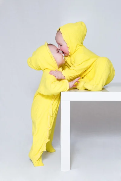 Дві милі маленькі дівчата в однакових жовтих костюмах Стокове Зображення
