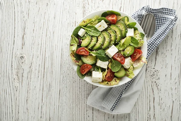木のテーブルの上にアボカドとフェタチーズと健康的な緑のサラダ — ストック写真