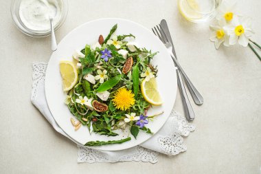 Karahindiba salatası, kuşkonmaz, yabani sarımsak, çiçekler, ısırgan otu ve krem peynir. Sağlıklı bahar detoks gıda malzemeleri.
