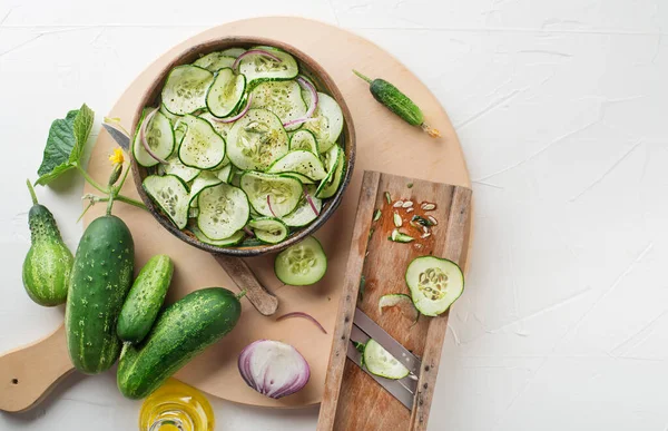 Cucumber salad. Preparation of fresh cucumber salad on white background