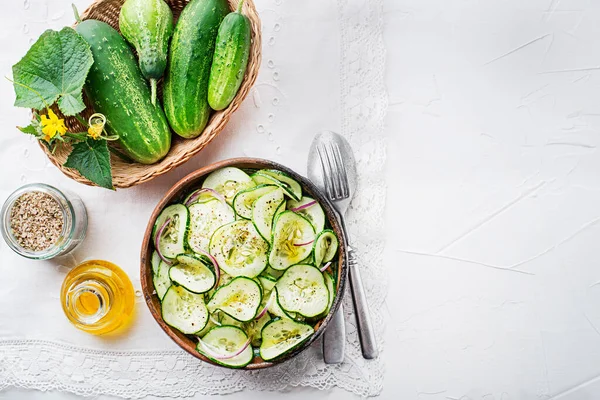Cucumber salad. Preparation of fresh cucumber salad on white table background