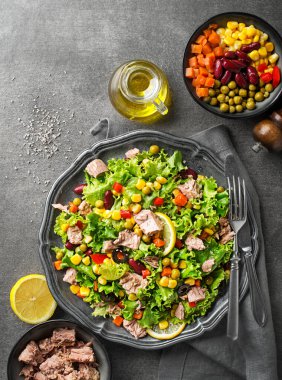 Healthy Green salad with tuna and vegetable on grey table background. Mexican corn salad.