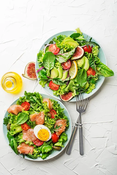 新鲜的绿色生菜沙拉 白桌背景上有熏鲑鱼 樱桃西红柿 鸡蛋和鳄梨 — 图库照片