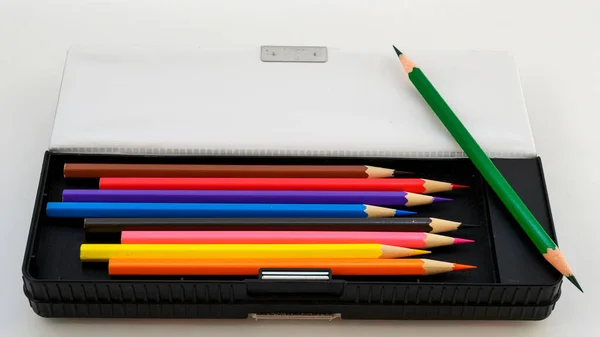 school pencil case with colored pencils on a white background