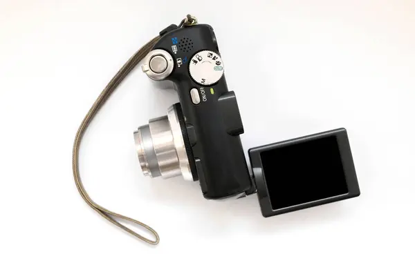 compact digital camera in black with a gray zoom lens and a rotary display on a white background close-up