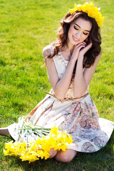Heureuse fille souriante avec des fleurs jaunes — Photo
