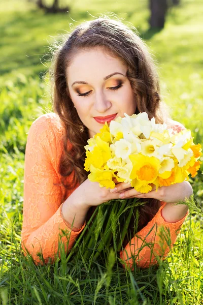 Menina sorridente feliz com flores amarelas — Fotografia de Stock