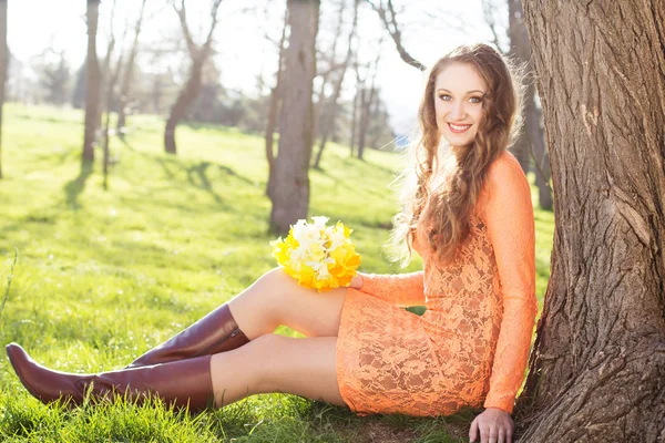 Gelukkig lachend meisje met gele bloemen — Stockfoto