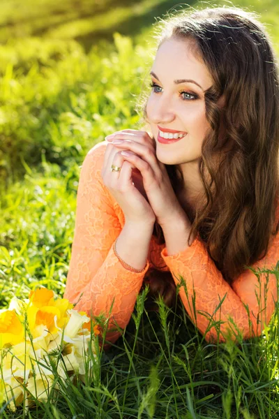 Happy smiling girl with yellow flowers daffodils — Stock Photo, Image