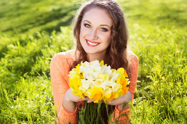 Menina sorridente feliz com flores amarelas — Fotografia de Stock