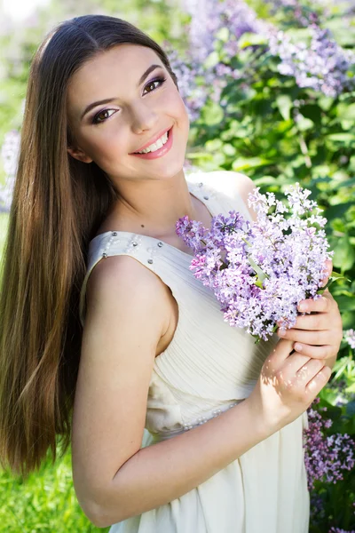 Mooi meisje met een lila bloemen — Stockfoto